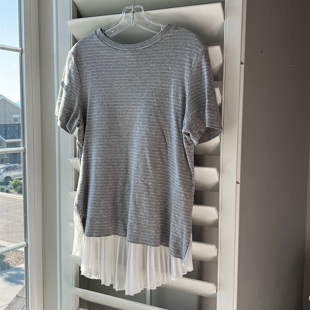 Classy gray and white striped blouse with ruffle on bottom in back.